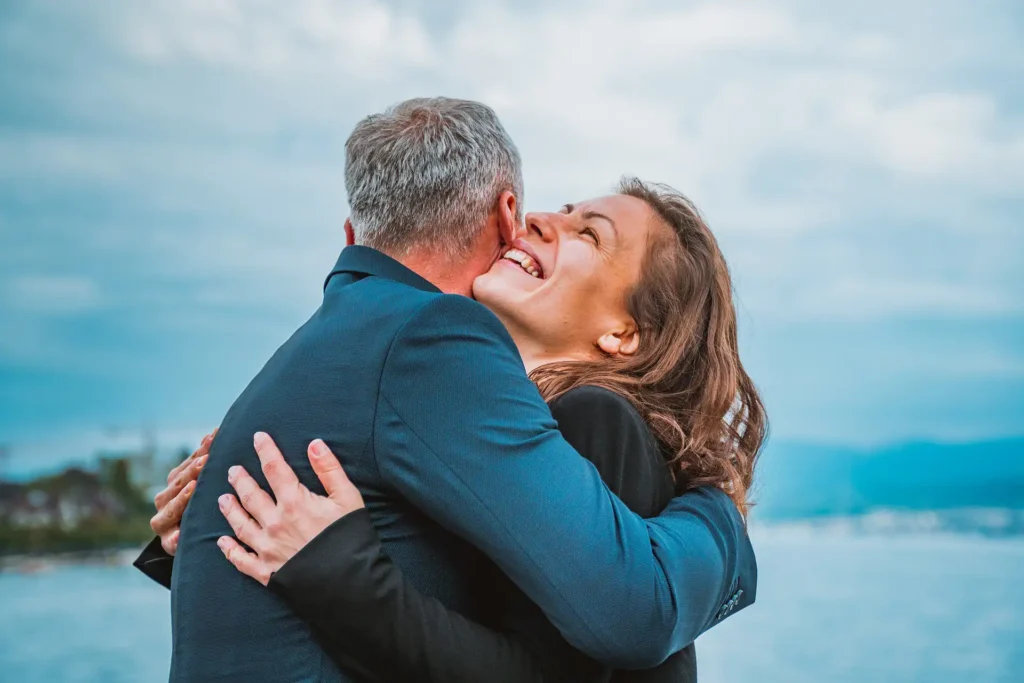 Nell'immagine una coppia che sorride e si abbraccia.