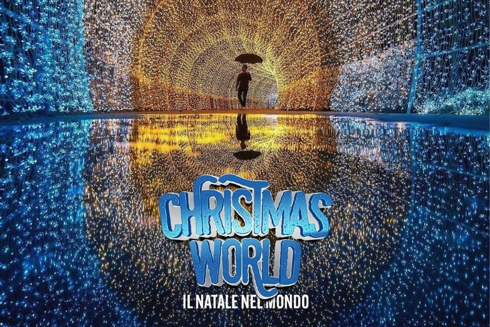 l'immagine rappresenta un sentiero ad arco fatto di luccine luminose blu, bianche e gialle con un uomo con l'ombrello in mezzo e il logo del Christmas world