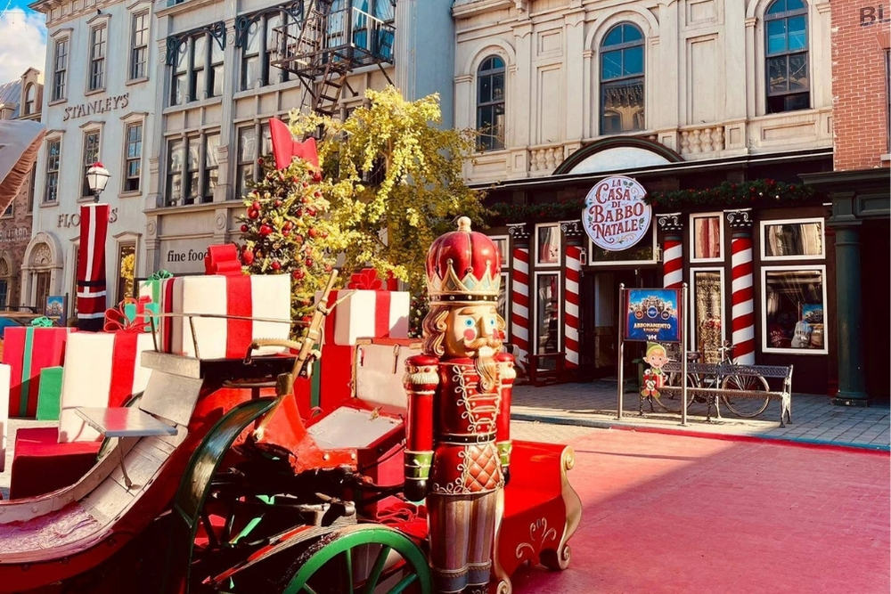 l'immagine rappresenta una delle vie di cinecittà world con una slitta con dei regali, uno schiaccianoci e dietro l'ingresso per la casa di babbo natale