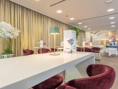 The picture shows the bar in the foreground and some of the tables behind it. On each table are lamps and the bar menu.