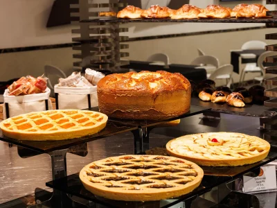 The picture shows part of the buffet with tarts, cakes, empty and filled brioche and rusks.