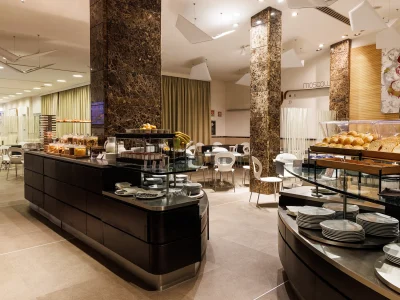 In the picture you can see the breakfast room with part of the buffet: there are some breads and in the distance you can see the buffet with yoghurt and cereals.