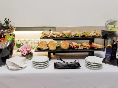 Nell'immagine una proposta del servizio banqueting. Un buffet allestito con: panini farciti, toast, focacce, insalate, condimenti e bevande fresche.