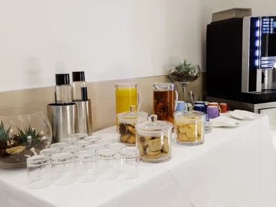 Nell'immagine una proposta del servizio banqueting. Un buffet allestito per il coffee break con biscotti di frolla, succhi di frutta e macchinetta per le bevande calde.
