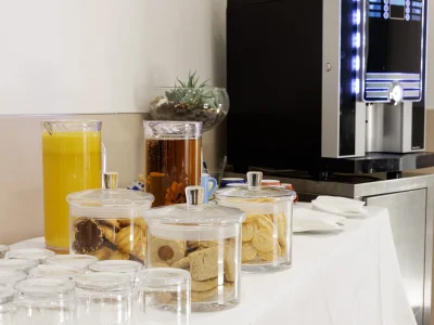 Nell'immagine una proposta del servizio banqueting. Un buffet allestito per il coffee break con biscotti di frolla, succhi di frutta e macchinetta per le bevande calde.