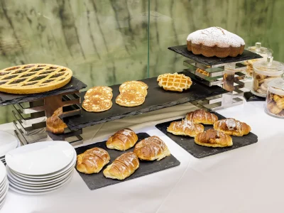 Nell'immagine una proposta del servizio banqueting. Un buffet allestito per il coffee break con brioche, torte, biscotti di frolla, pancakes e waffle.