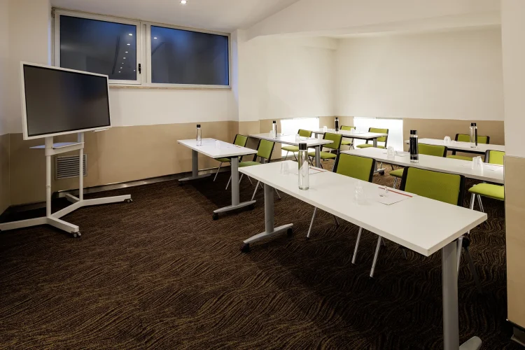 Nella foto, la sala riunioni Priscilla con la disposizione dei banchi della scuola. Per ogni banco ci sono due postazioni e davanti uno schermo per le proiezioni.