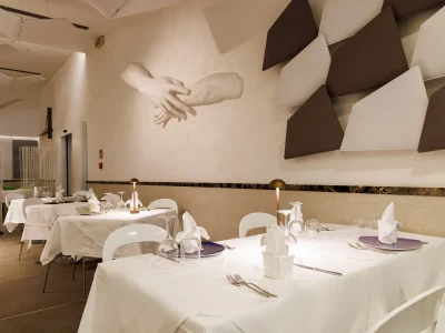 Nell'immagine si vede la sala del Ristorante The White. Tutti i tavoli sono apparecchiati con tovaglie bianche.
