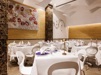 Nell'immagine si vede la sala del Ristorante The White. Tutti i tavoli sono apparecchiati con tovaglie bianche.